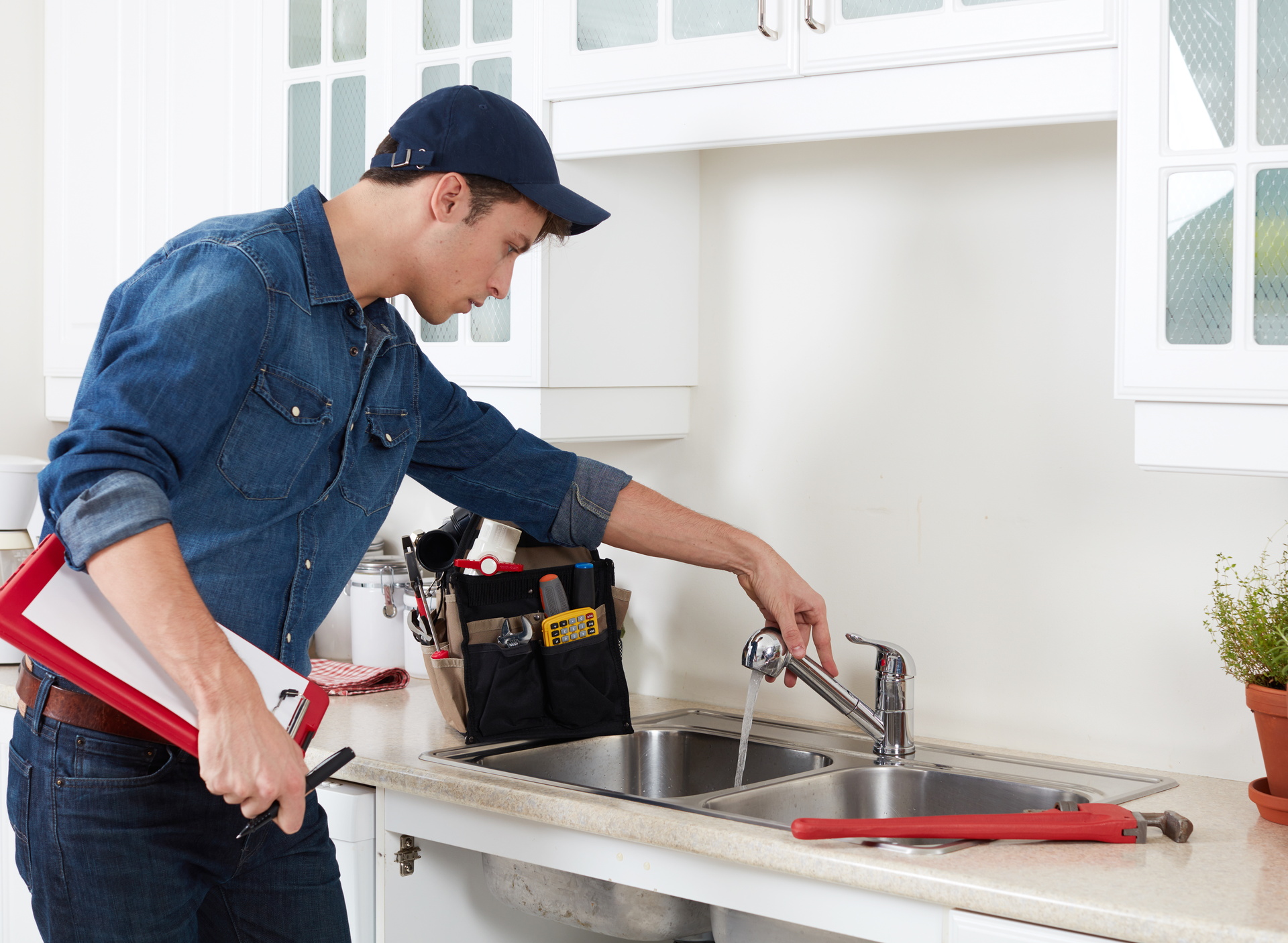 A handyperson repairing kitchen faucet