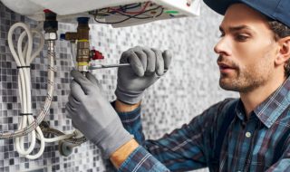 Wrench always with you. Worker set up electric heating boiler at home. Close-up of young handyman